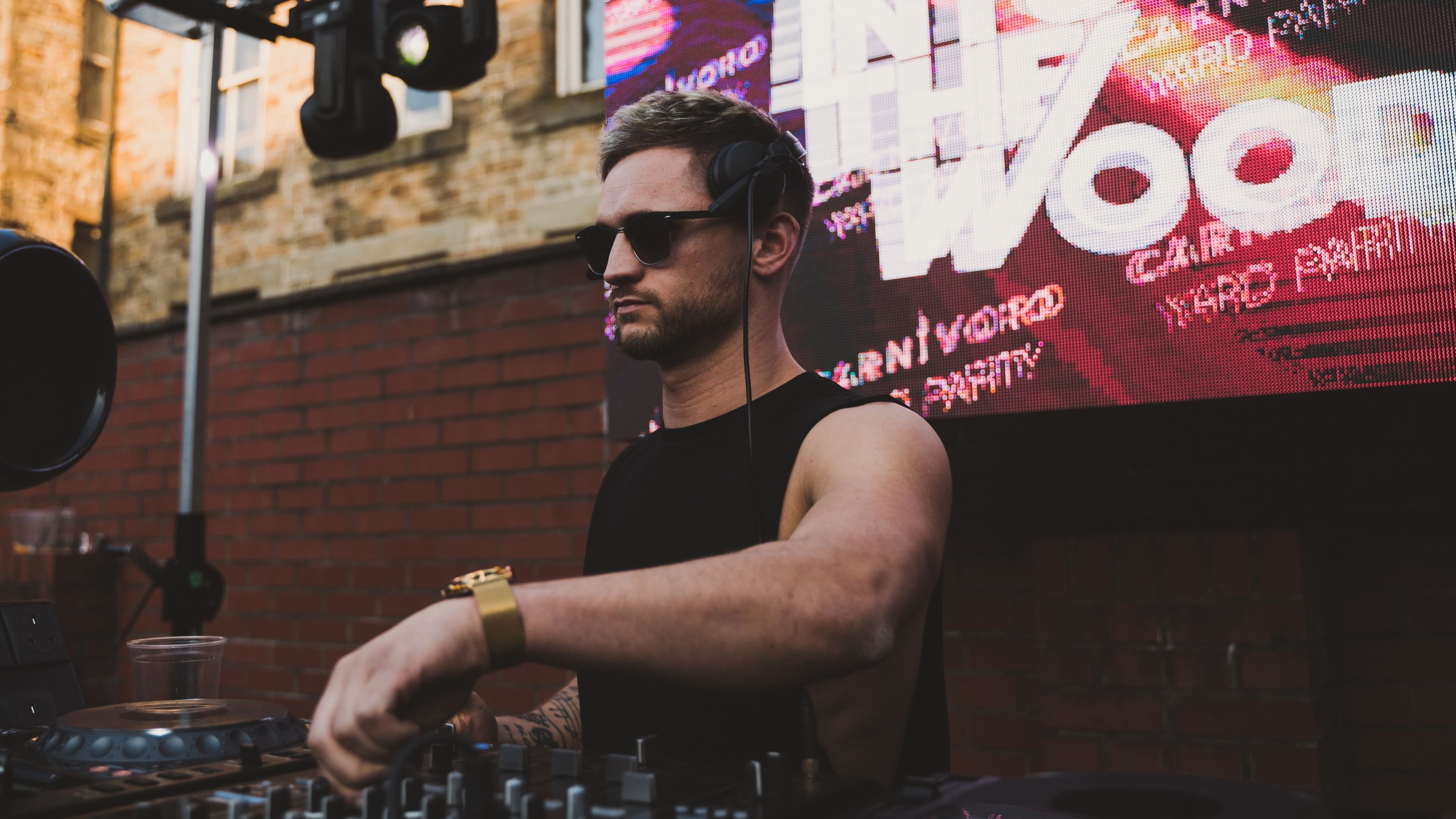 Chris Sarchet Bell DJing on an outdoor rooftop stage, 2014