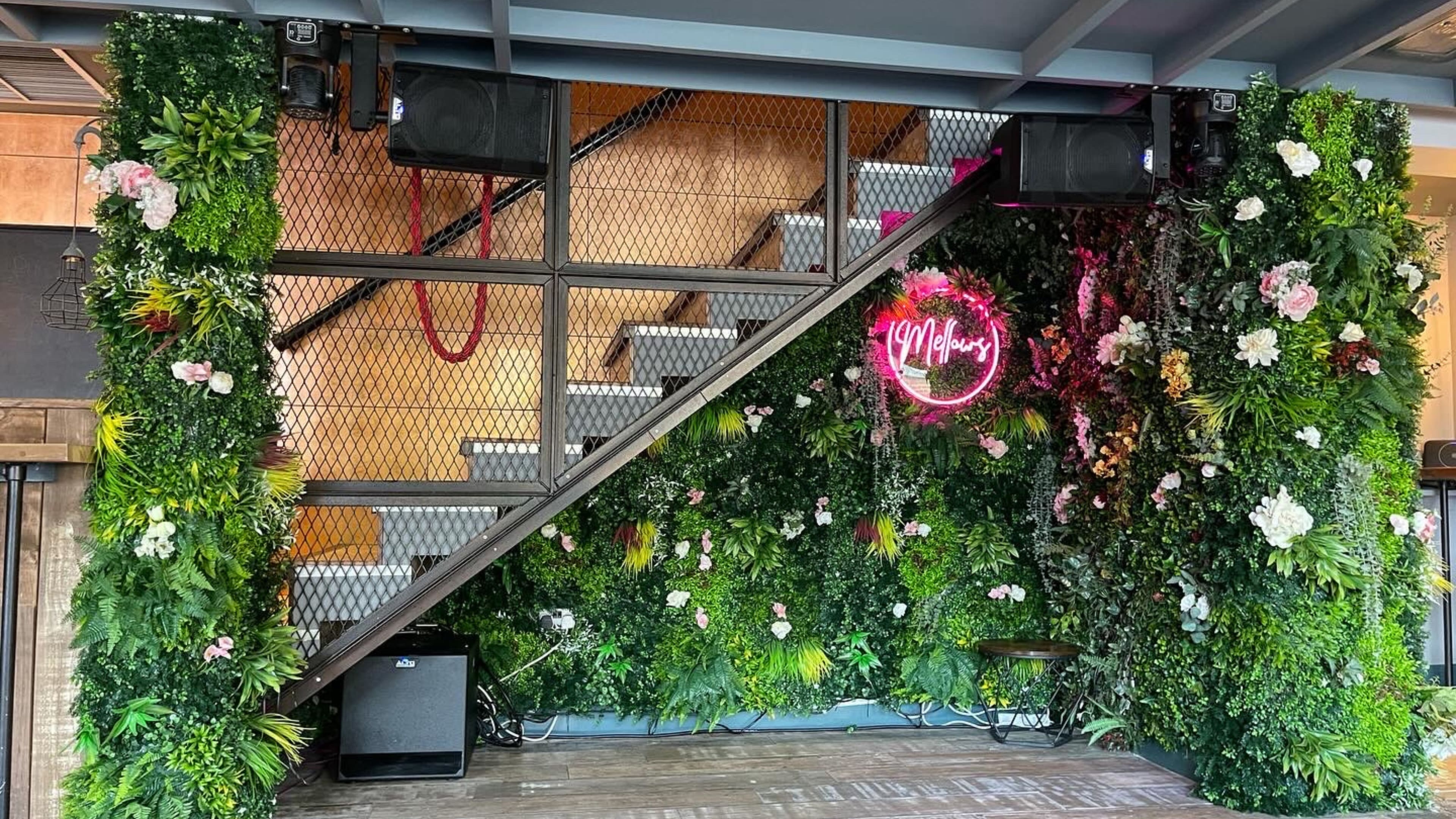 Greenery-covered staircase feature inside the refurbished bar, 2023